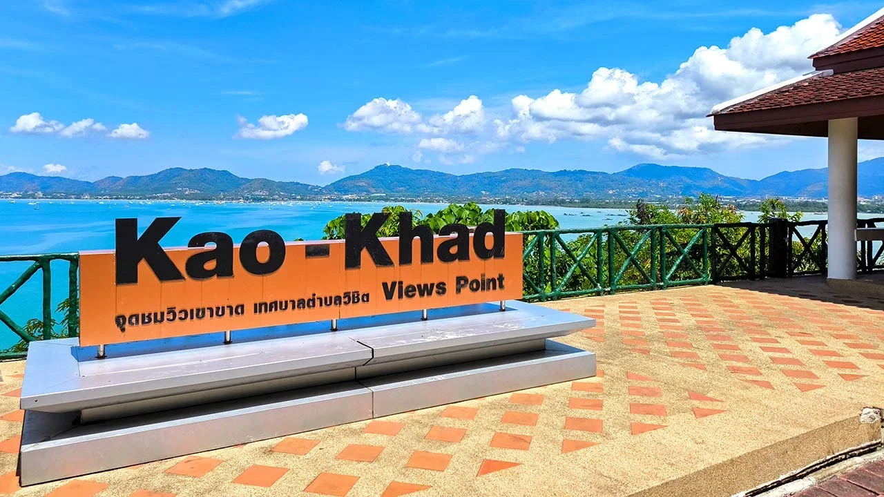 Смотровая площадка Као Кхад: оранжевая вывеска Kao-Khad Views Point, павильон с черепичной крышей и вид на бухту Чалонг