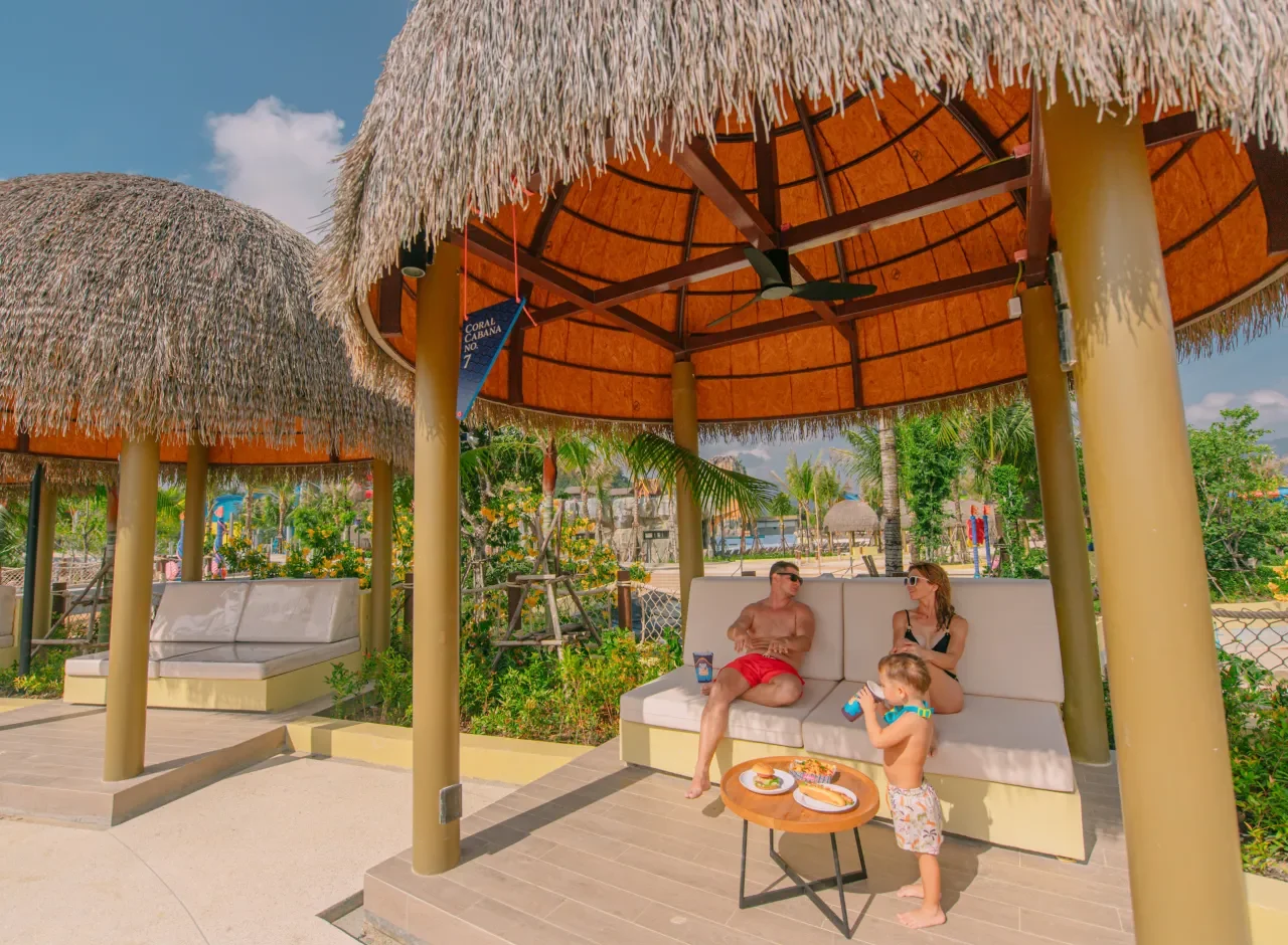 Семья отдыхает под соломенной крышей беседки Coral Cabana в Андаманде