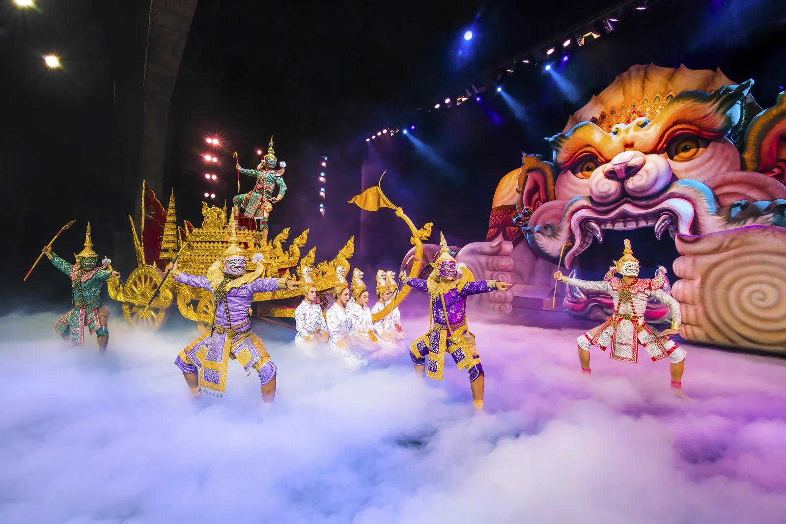 Представление Phuket FantaSea: актёры в масках кхон у золотой колесницы на фоне гигантской львиной маски