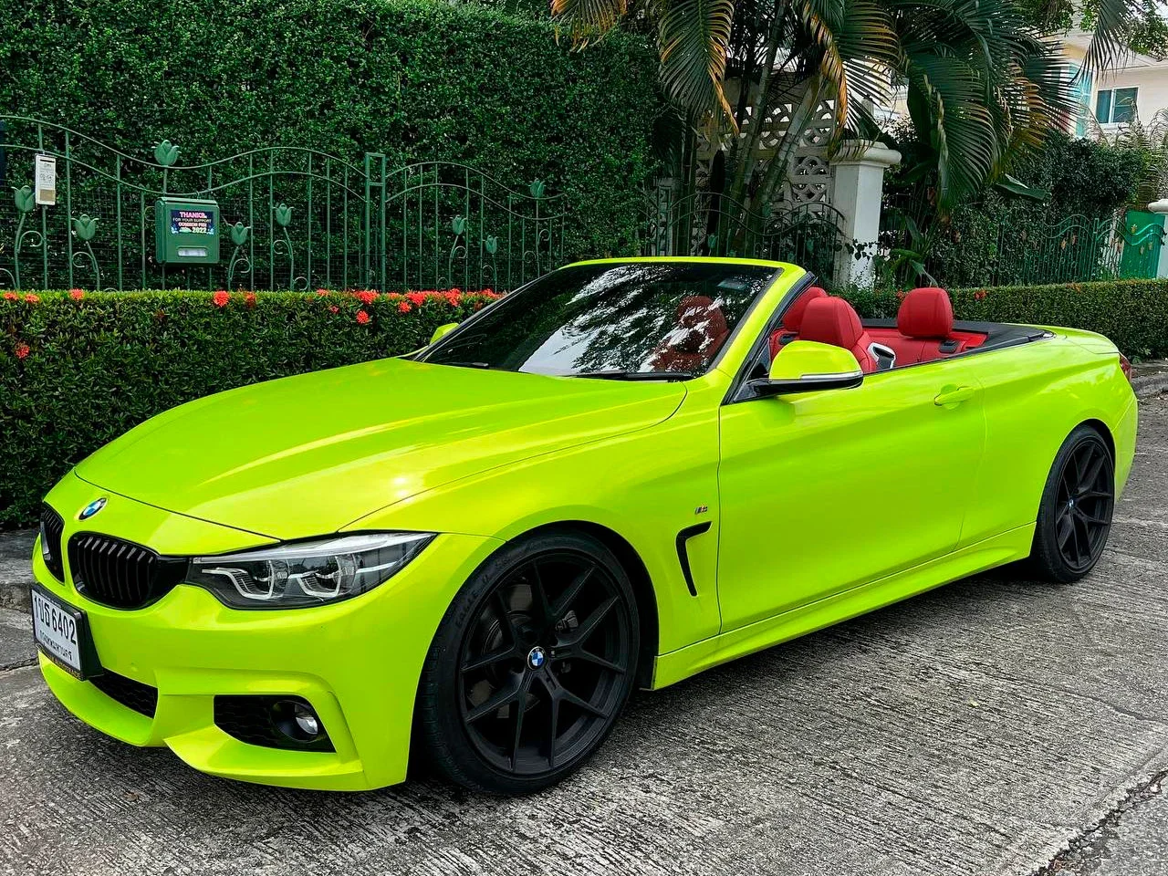 Ярко-салатовый BMW 430i кабриолет с красным кожаным салоном и чёрными дисками на подъездной дорожке на Пхукете