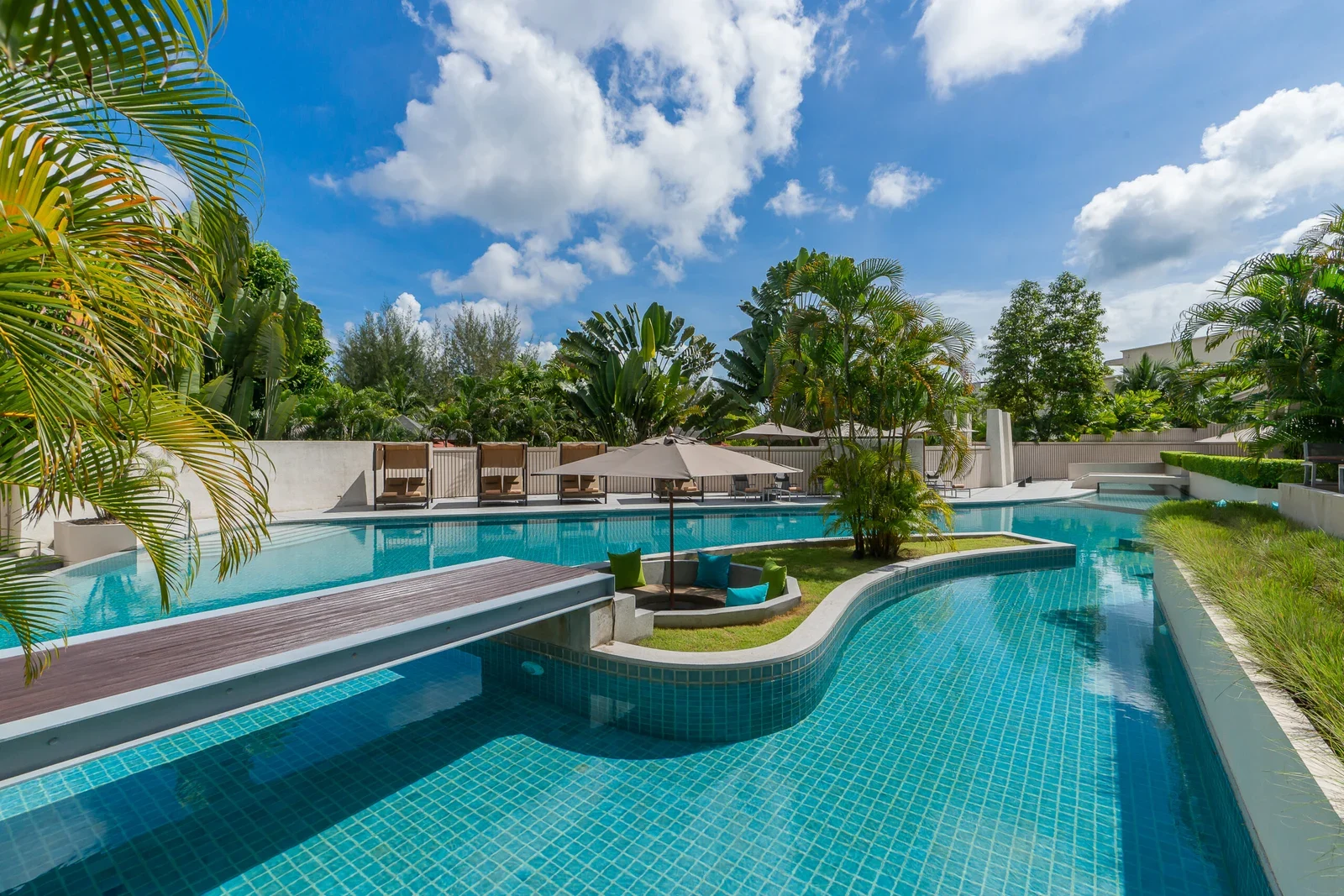 Извилистый бассейн с деревянным мостиком и островком с подушками, Dewa Phuket Resort & Villas
