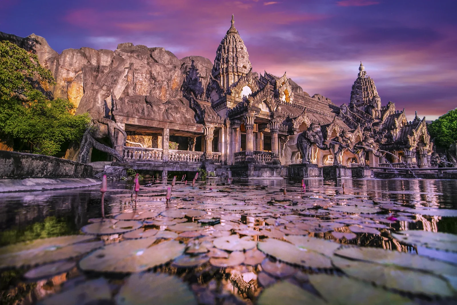 Каменный фасад театра Phuket FantaSea со скульптурами слонов и отражением в пруду