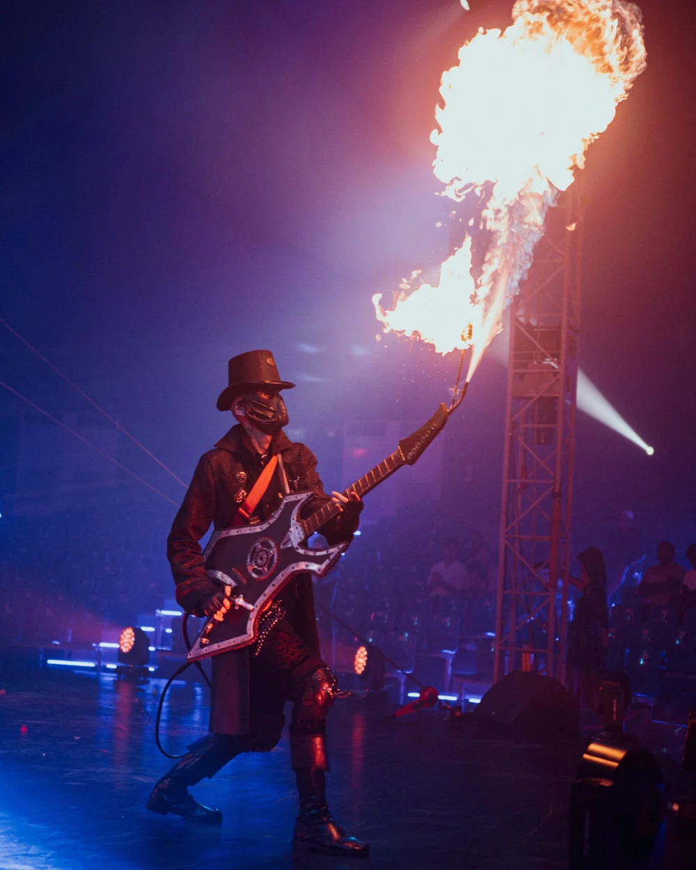 Артист с гитарой выступает в Phuket Circus на фоне вспышки огня и сценического света