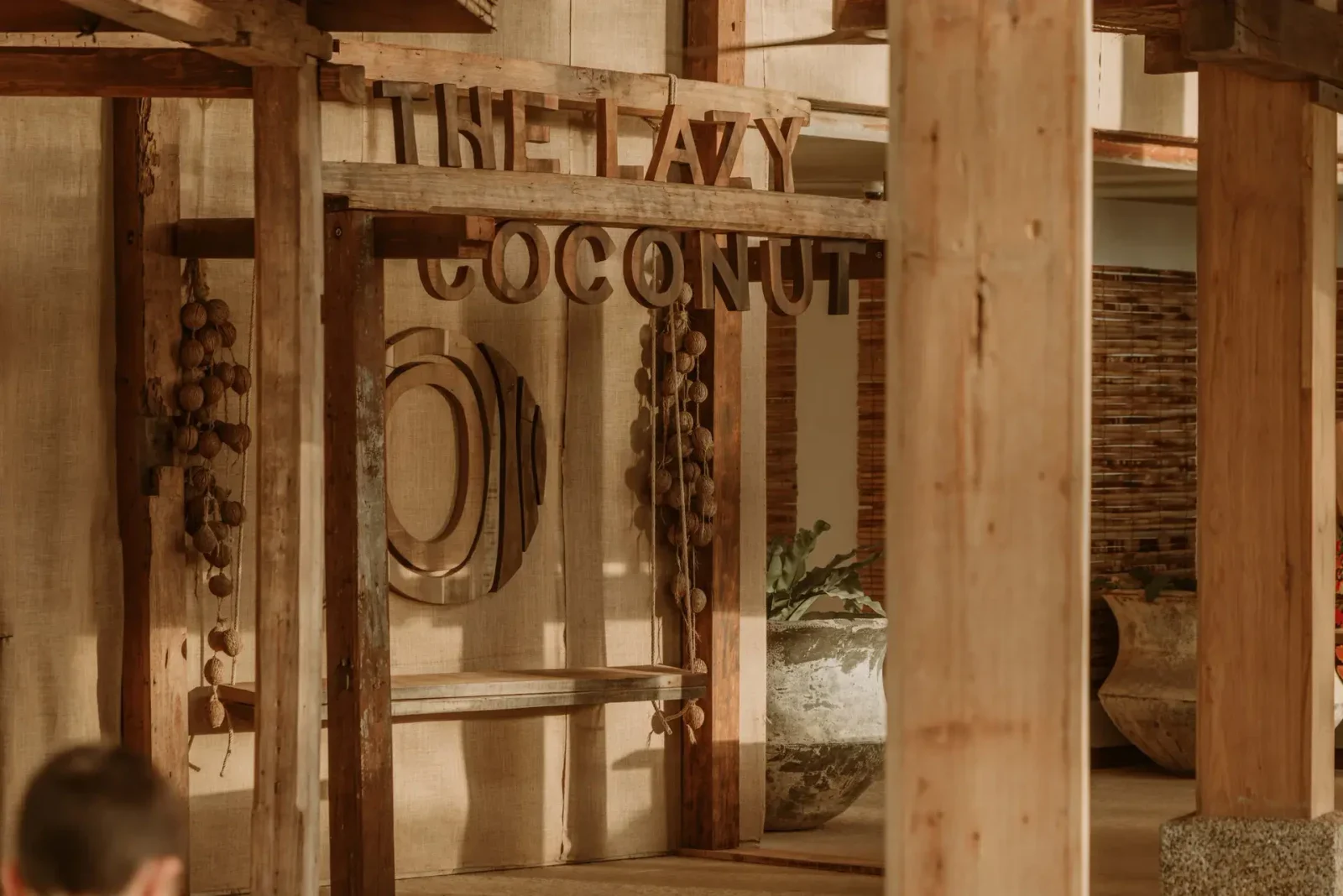 Деревянная вывеска The Lazy Coconut у входа в ресторанную зону клуба