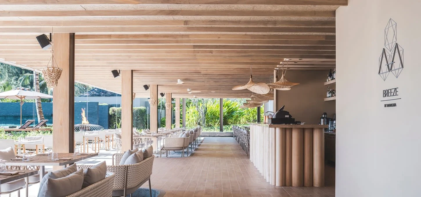 Зал Breeze в Beach House Layan с деревянными стульями и барной стойкой