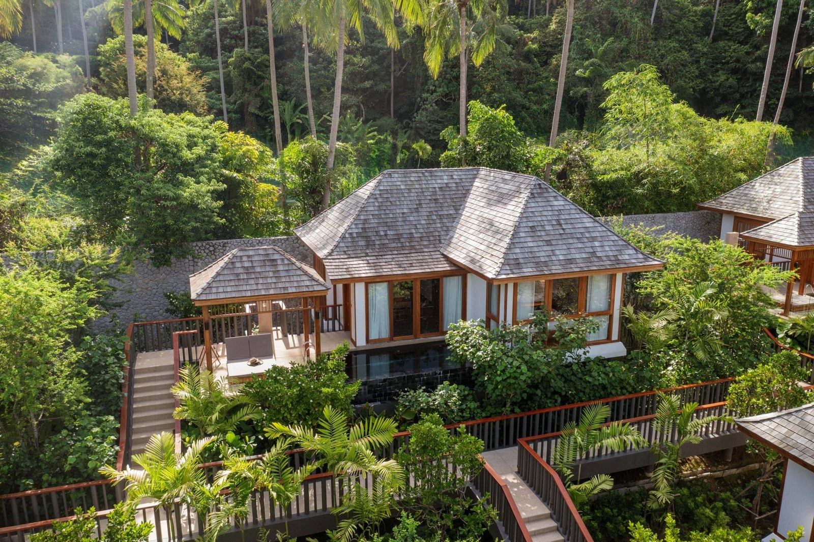 Бассейн-вилла The Surin Phuket с черепичной крышей, частным бассейном, беседкой и деревянными дорожками среди джунглей