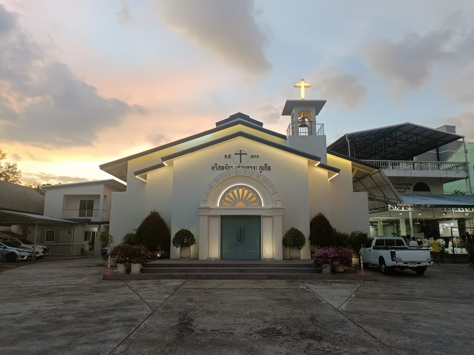 Церковь Phuket Church · Тха Кхрэнг: освещённое здание церкви с крестом в сумерках