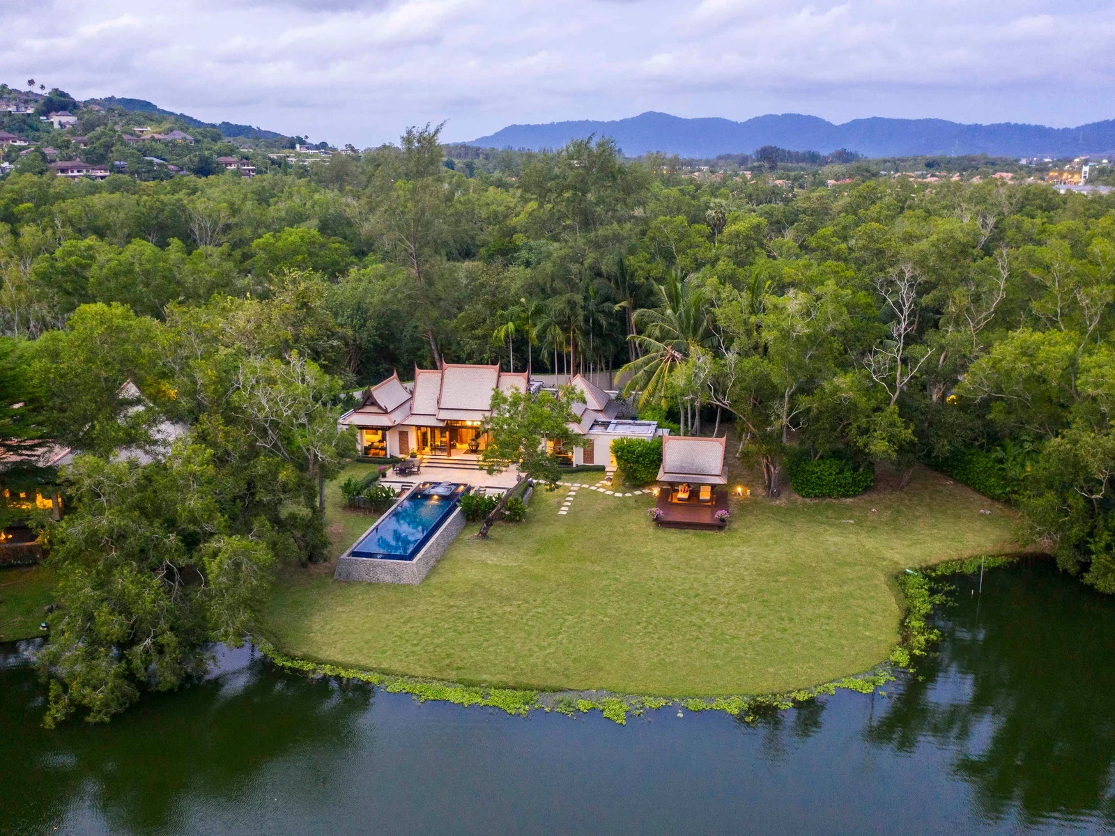 Вилла Banyan Tree Phuket у лагуны с длинным бассейном, отдельной беседкой и просторной лужайкой среди деревьев.