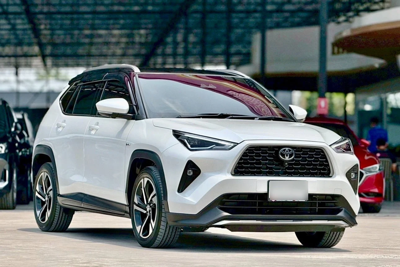 Белый Toyota Yaris Cross показан спереди под навесом автопарка PhuketAutoRental.