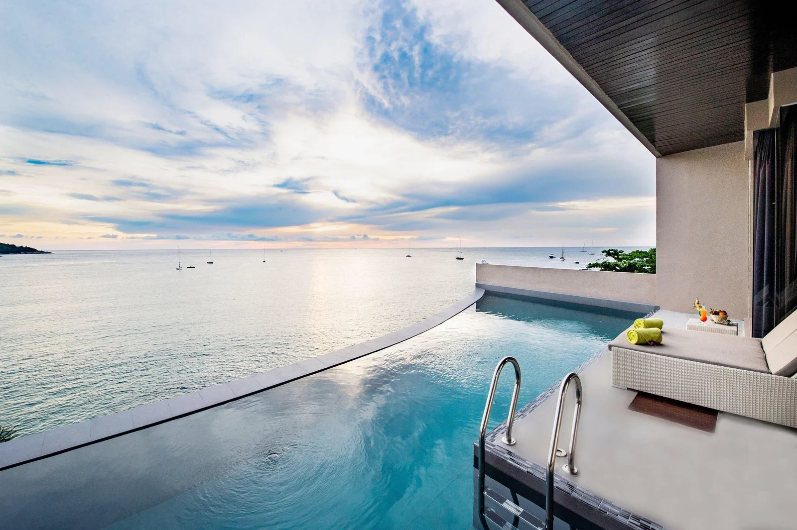 Бассейн Impiana приватный Villas Kata Noi тянется вдоль морской террасы с лежаком и металлической лестницей.
