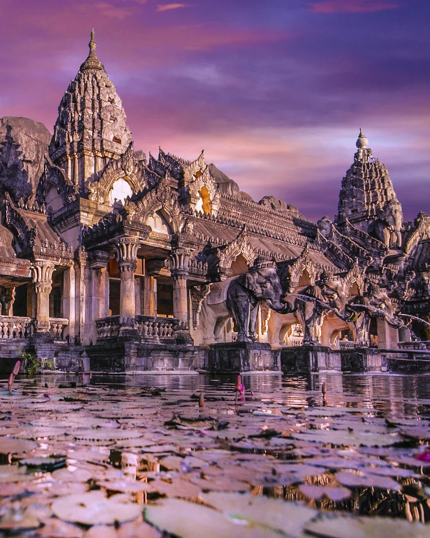 Каменный фасад театра Phuket FantaSea со скульптурами слонов и отражением в пруду