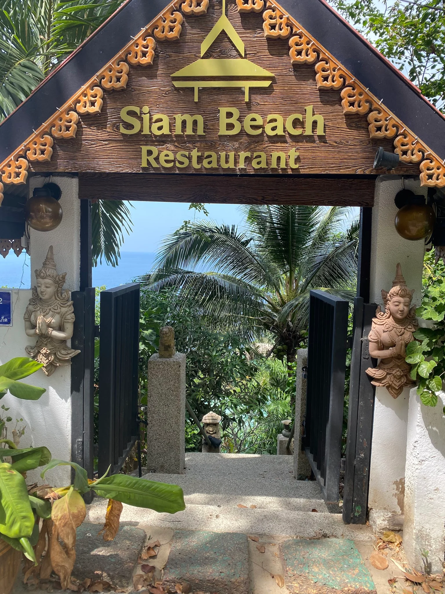 Вывеска Siam Beach Restaurant над проходом к старой береговой лестнице
