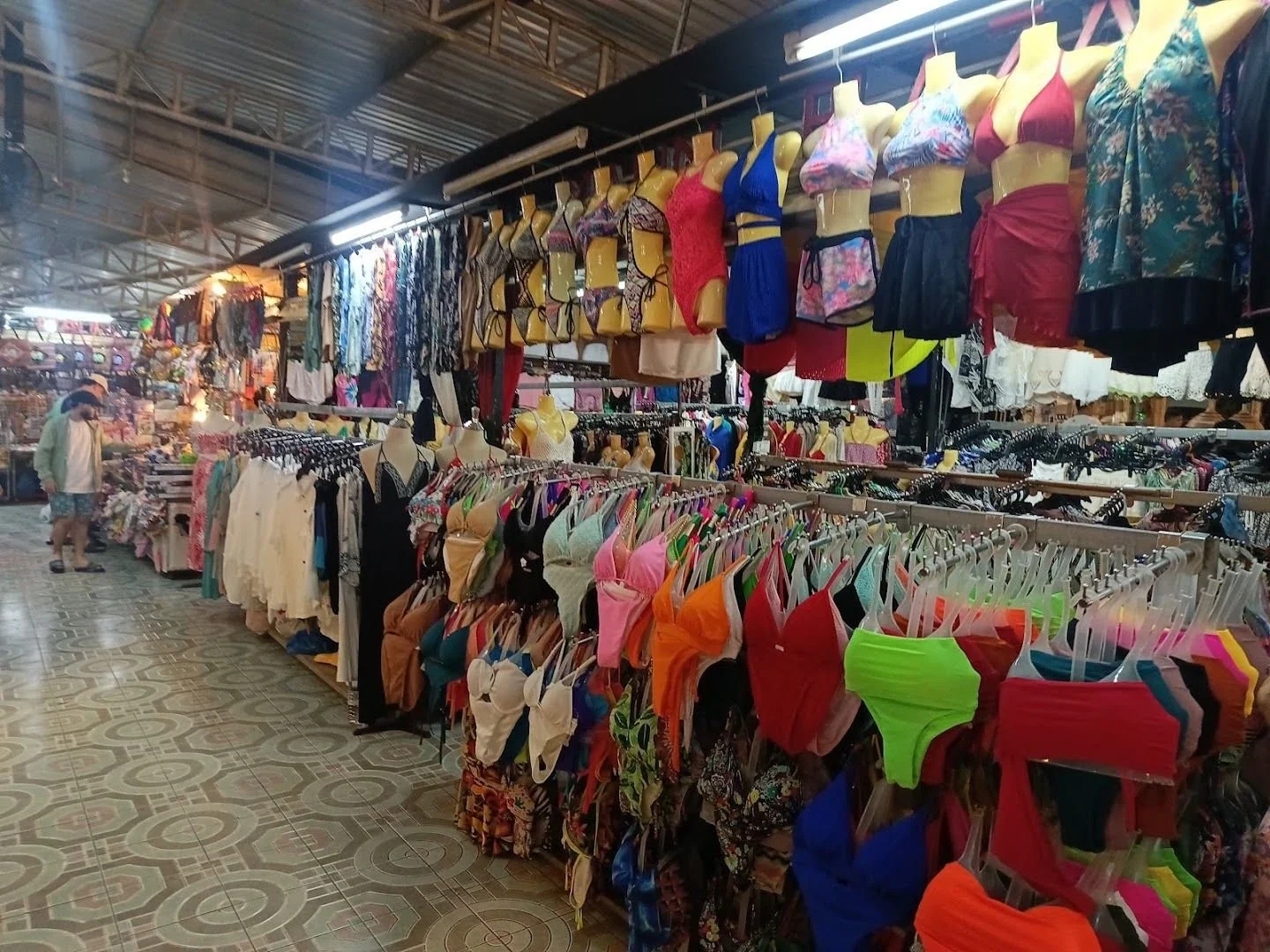 Купальники, пляжные платья и одежда на прилавках крытого рынка Malin Plaza