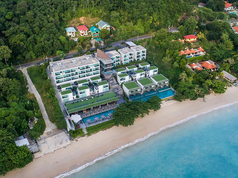 Берег Као Кхад и здания My Beach Resort сверху, между морем и зелёным склоном.