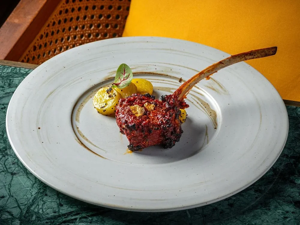 Мясо на косточке на белой тарелке в Tambu