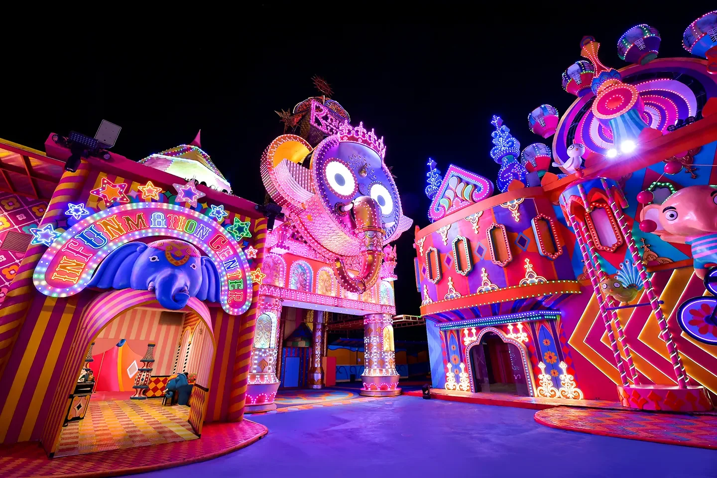 Ночная улица Carnival Funfair с яркими фасадами и крупными сказочными фигурами
