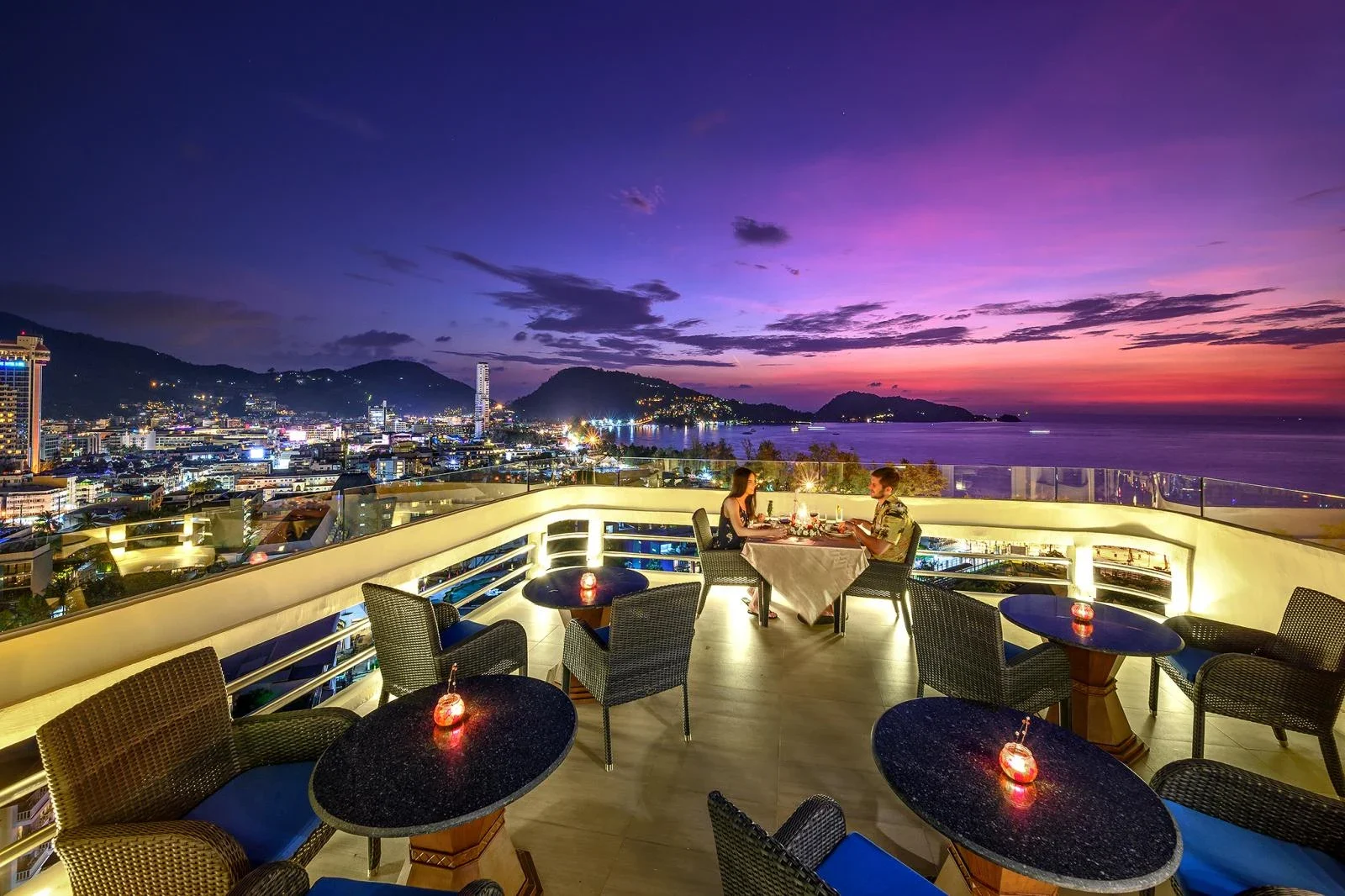 Терраса Andaman Sky Lounge в сумерках: столики со свечами, под ними вечерний Патонг