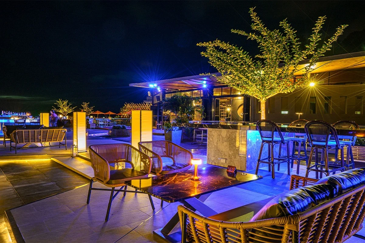 Ночная терраса Malika Sky Bar с подсвеченными колоннами, креслами и барной стойкой