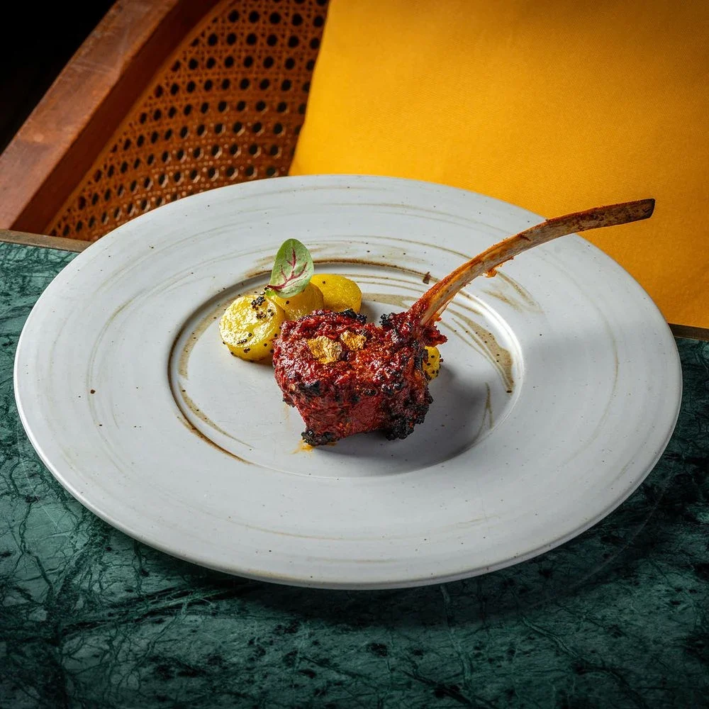 Мясо на косточке на белой тарелке в Tambu