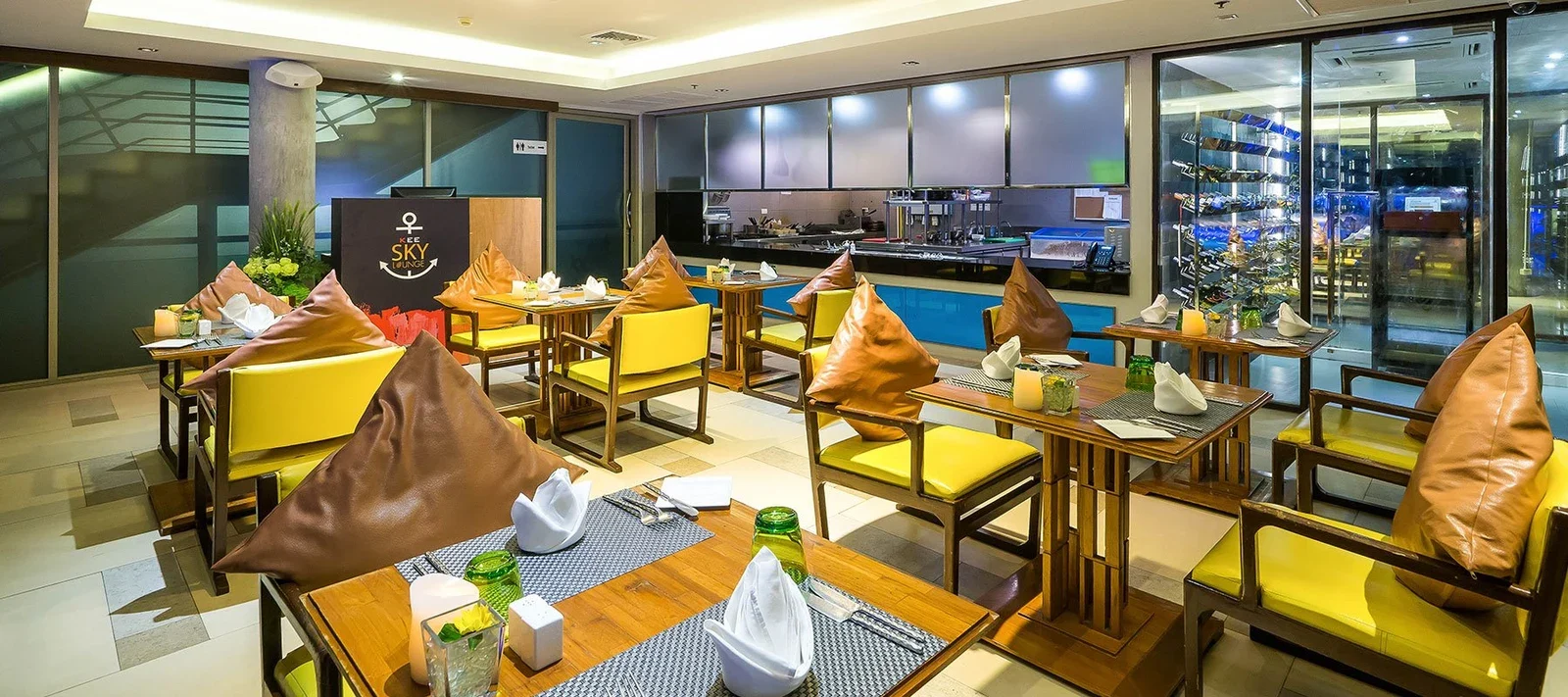 Внутренний зал Kee Sky Lounge: накрытые столы, открытая кухня и винный шкаф за стеклом