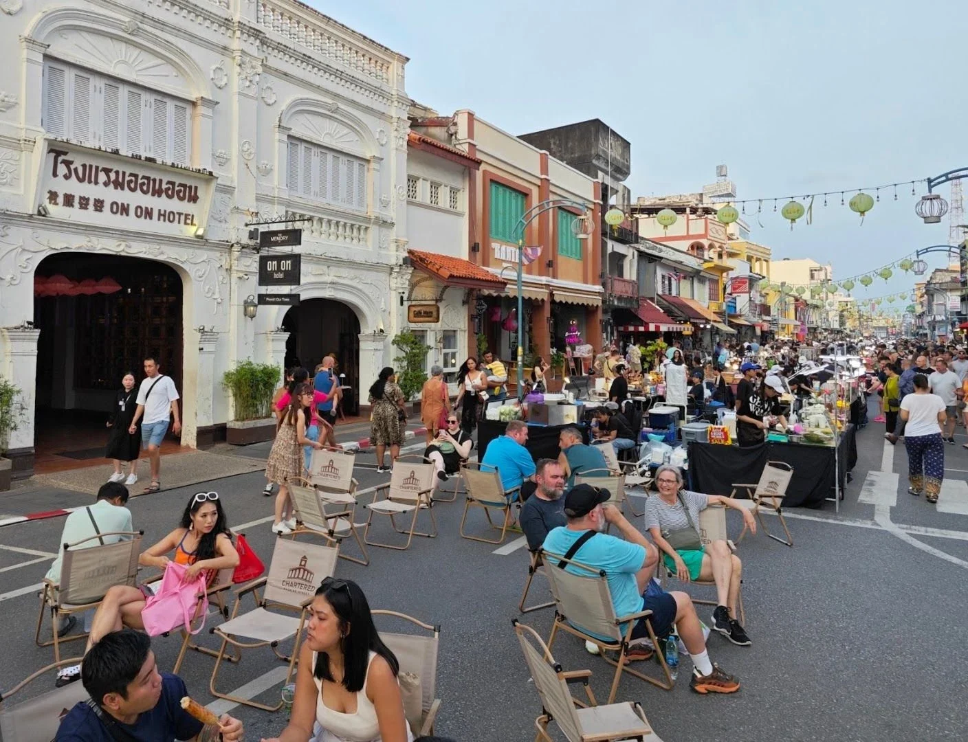 Посетители отдыхают в креслах среди торговых рядов Chartered Walking Street у отеля On On
